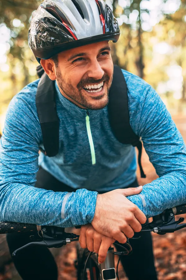 A smiling man getting ready for a cycling trip. Get treatment for adrenal hormone disorder from Morgan Burns, APRN in New Smyrna Beach.