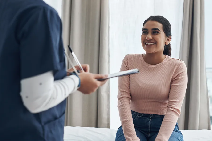 A woman speaks to a clinician before a physical exam. Get adult physical exams from Morgan Burns, APRN in New Smyrna Beach.