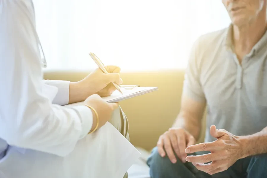 A clinician takes notes while speaking with a patient. Schedule an annual wellness exam from Morgan Burns, APRN in New Smyrna Beach.