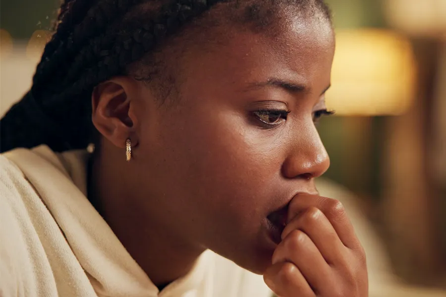 A black woman bites her nails with worry. Get treatment for anxiety from Morgan Burns, APRN in New Smyrna Beach.