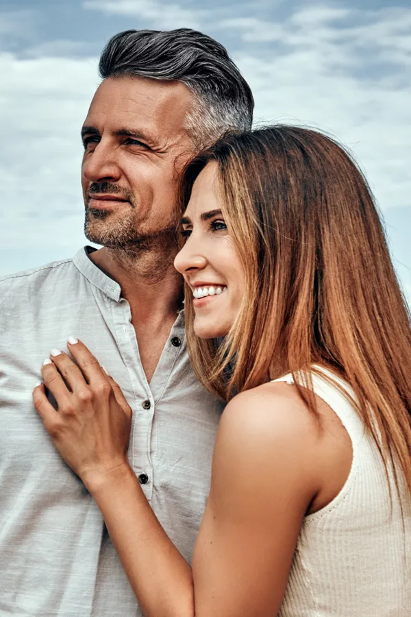 A middle-aged couple smile as they look to the horizon. Get DNA and genetic testing from Morgan Burns, APRN in New Smyrna Beach.