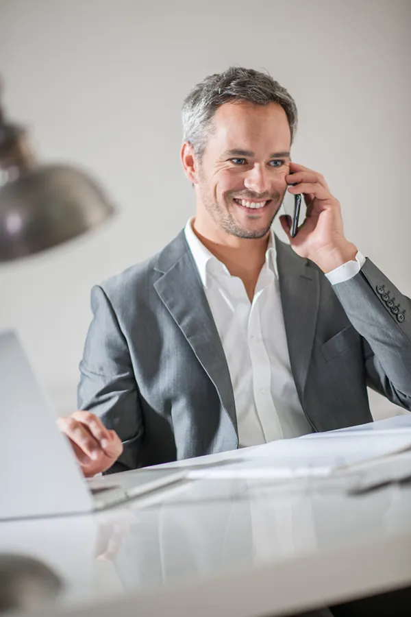 A man takes care of a call at work. Get treatment for focus issues from Morgan Burns, APRN in New Smyrna Beach.