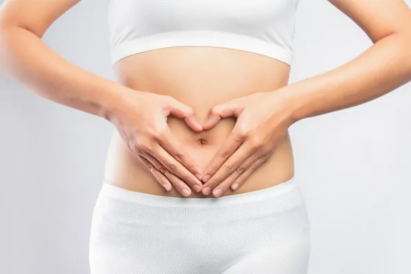 A woman holds her hands over her belly in a heart shape. Get Gut Repair Peptides treatment from Morgan Burns, APRN in New Smyrna Beach.