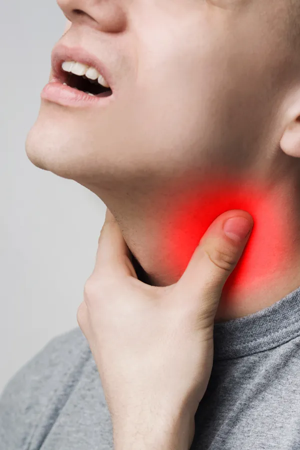 A man holds his throat in pain. Get thryoid testing from Morgan Burns, APRN in New Smyrna Beach.