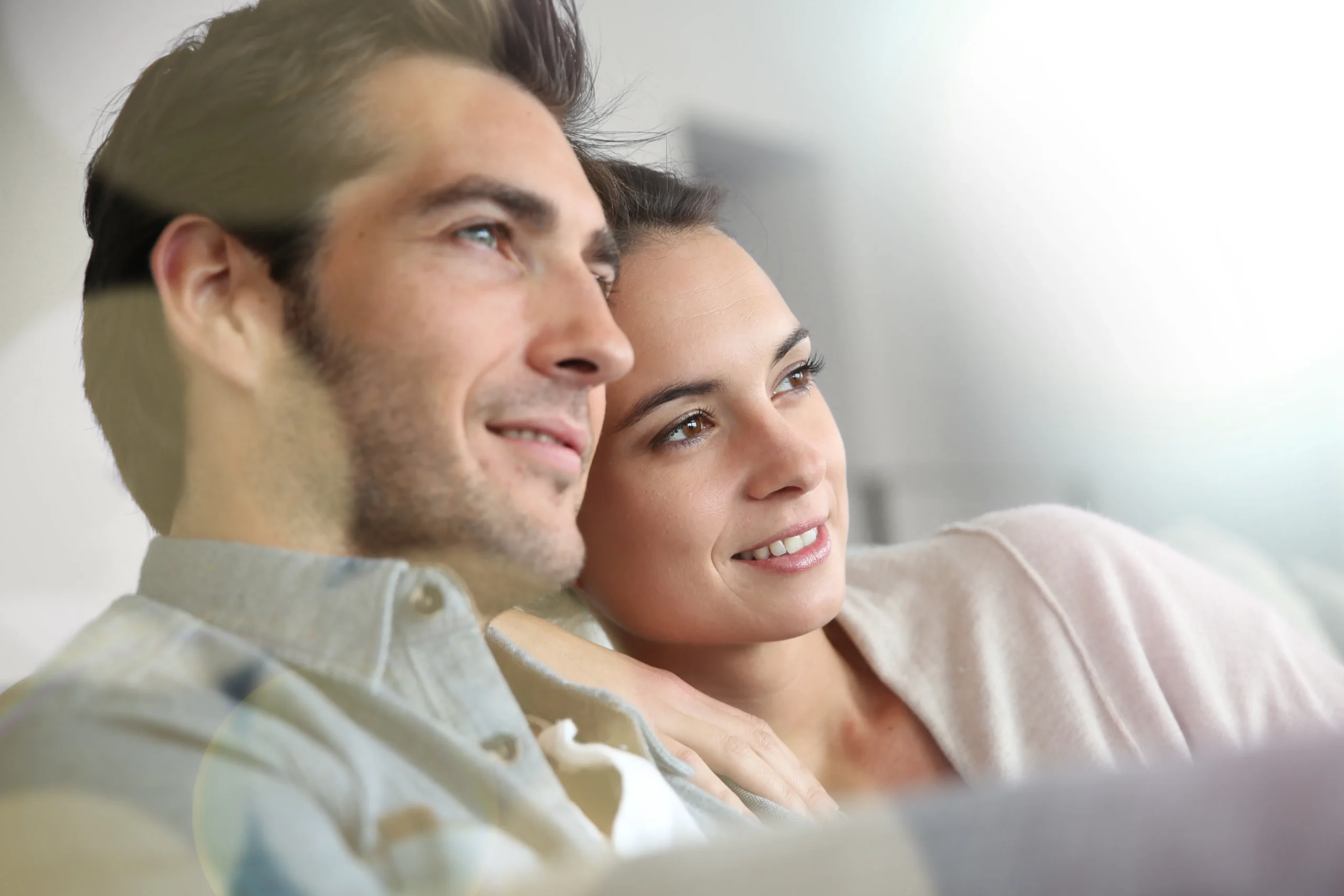 Bioidentical-Hormone-Replacement-Therapy-Clinic A smiling couple relaxes on their couch and looks out at the horizon. Get Bioidentical Hormone Replacement Therapy from Brandi Terra, NP at Oak & Stone Wellness in San Diego.