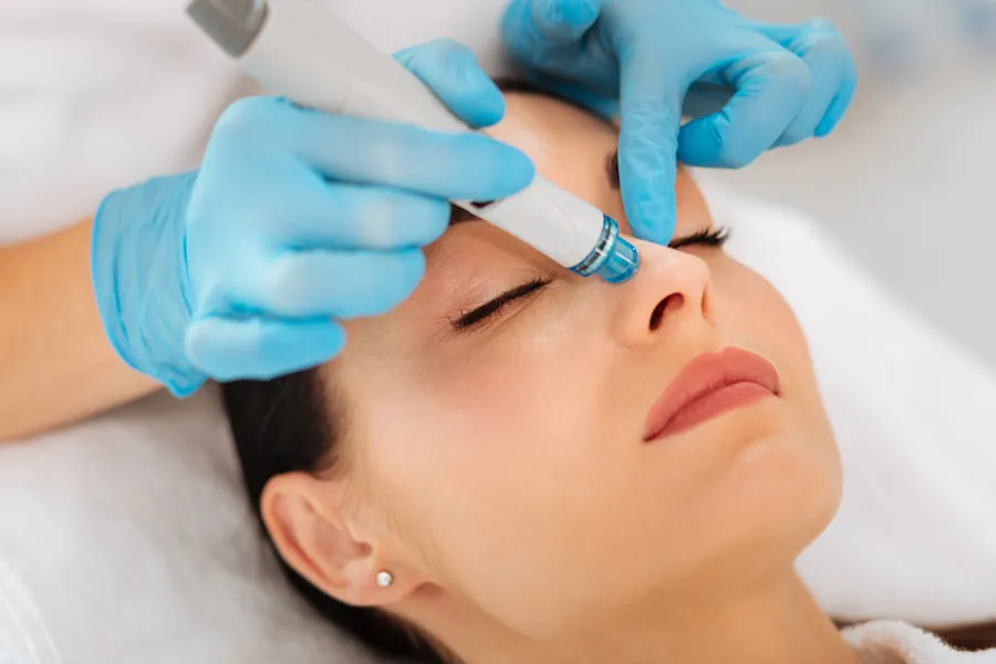 A woman gets a hydrafacial treatment from Brandi Terra, NP at Oak & Stone Wellness in San Diego.