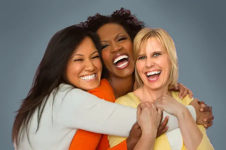 An asian, black, and white woman of middle age hug and laugh. Get insulin resistance treatment from Brandi Terra, NP at Oak & Stone Wellness in San Diego.