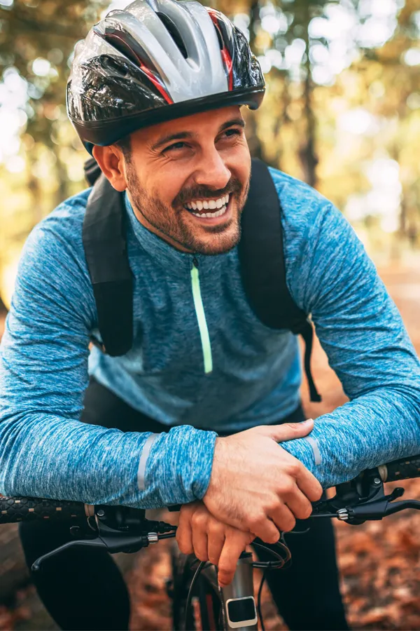 A man clutches his abdomen, with a digital illustration of inflamed intestines glowing in red. Brandi Terra, NP at Oak & Stone Wellness offers advanced inflammatory bowel disease (IBD) treatment in San Diego using functional medicine and gut-focused therapies.